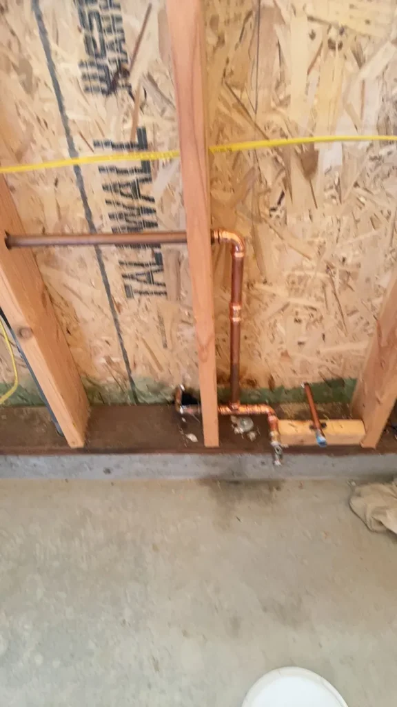 New plumbing routed through the open wall framing.
