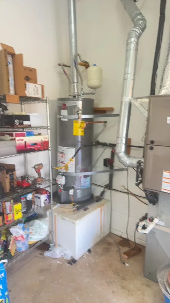 The water heater and connected pipework in the garage.
