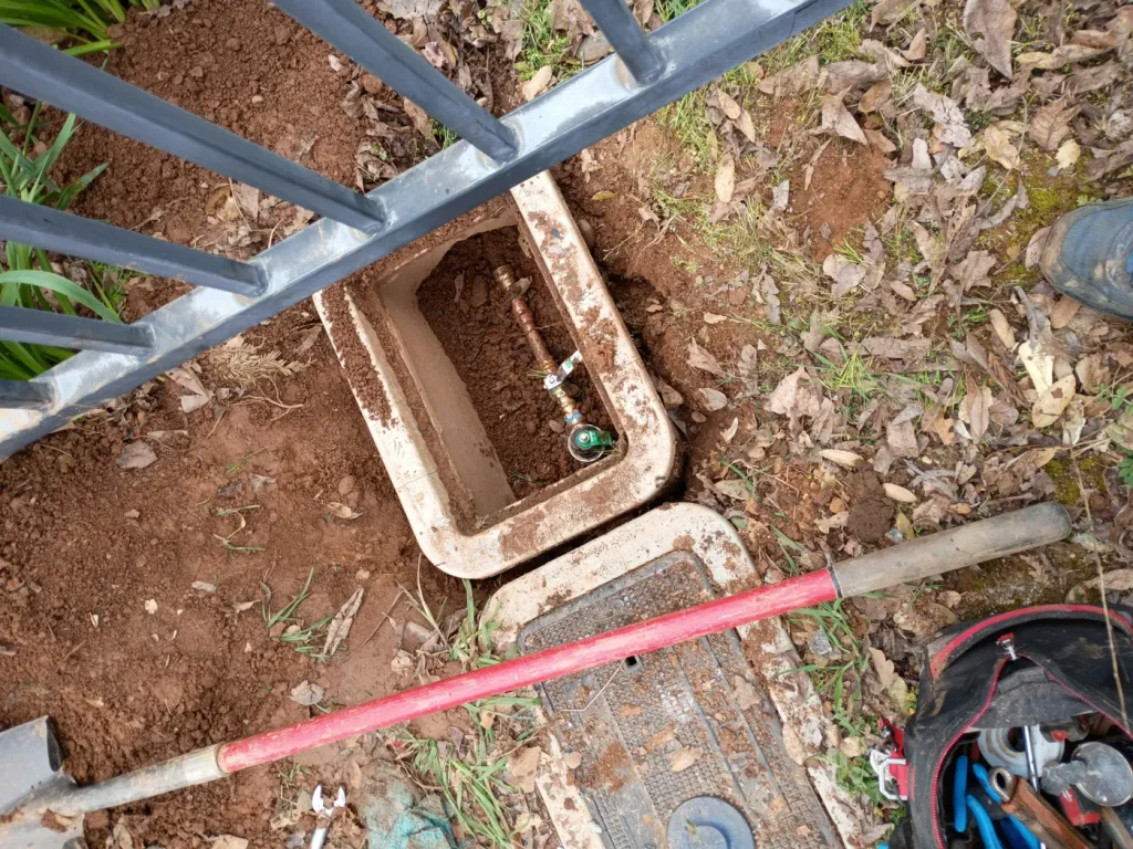 The excavated water-line connection and service boxes.