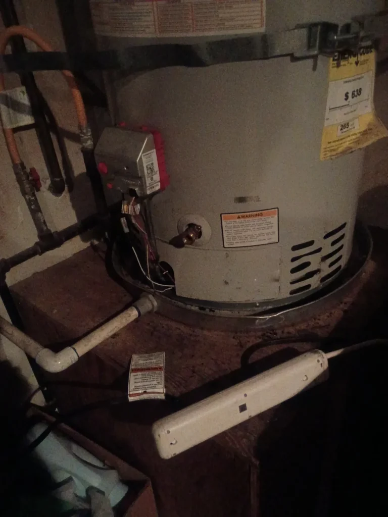 The water heater burner area opened for service.