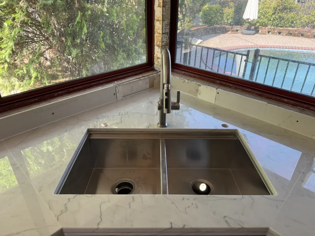 The installed kitchen sink beneath the window.