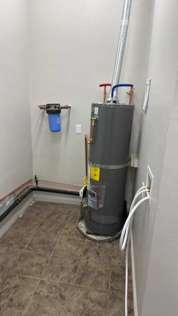 The installed water heater and its plumbing connections.