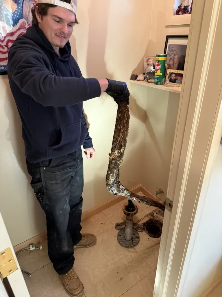A Murray technician holding the root mass removed on the job.
