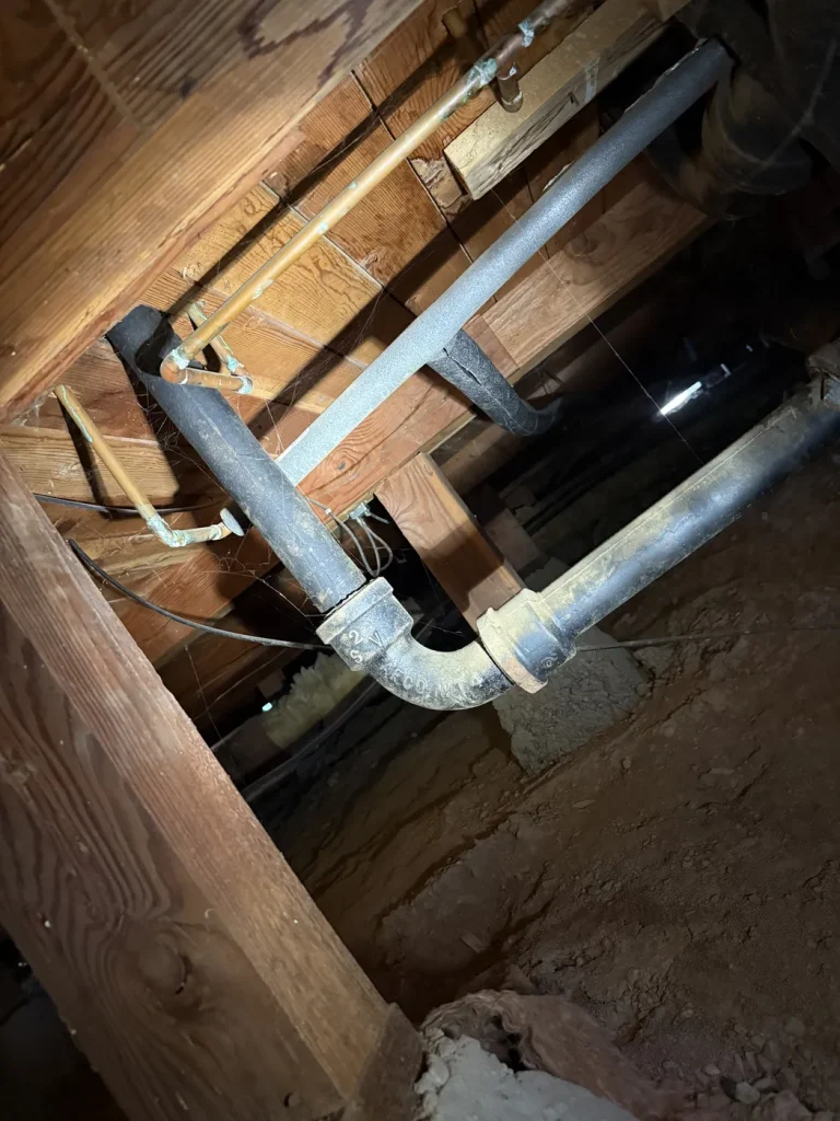 The sink drain piping and connections beneath the floor.