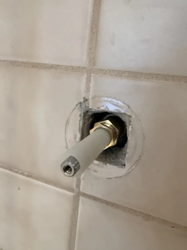 A close view of a shower cartridge connection.