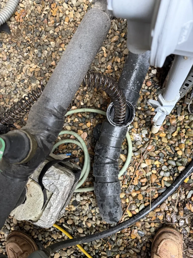 The drain snake entering the sewer access opening.