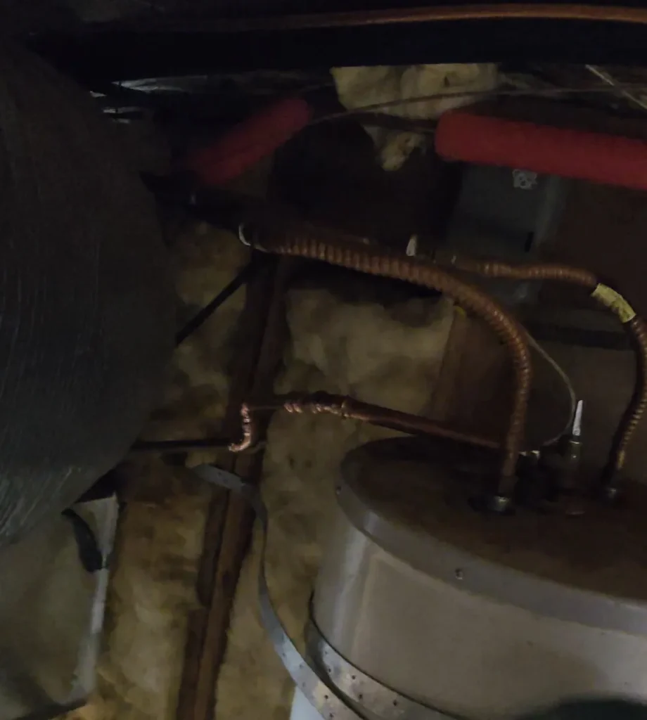 The water heater and connections in the repair area.
